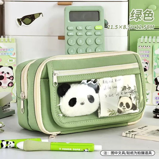 Sage green pencil pouch with transparent front pocket and heart clip detail on study desk lifestyle shot